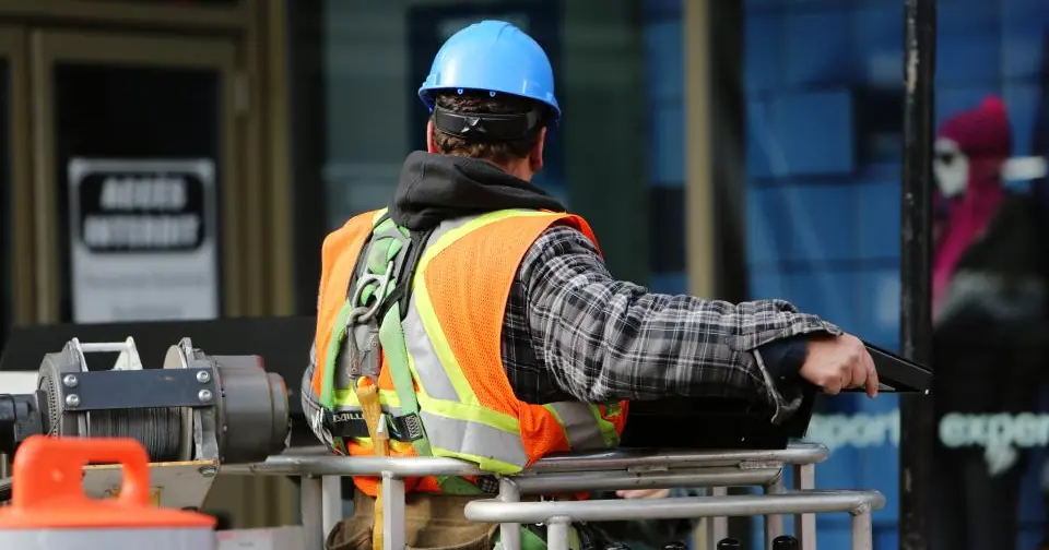 Worker in a hard hat and reflective vest at a construction site