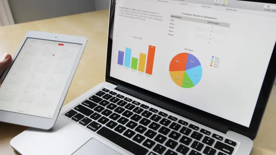 Laptop showing bar and pie charts next to a tablet