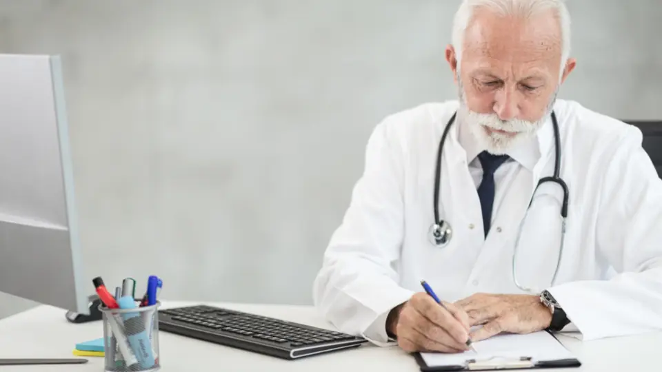 Doctor writing at his office desk