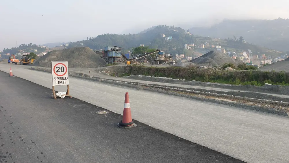 Road under construction with traffic cones and a speed limit sign