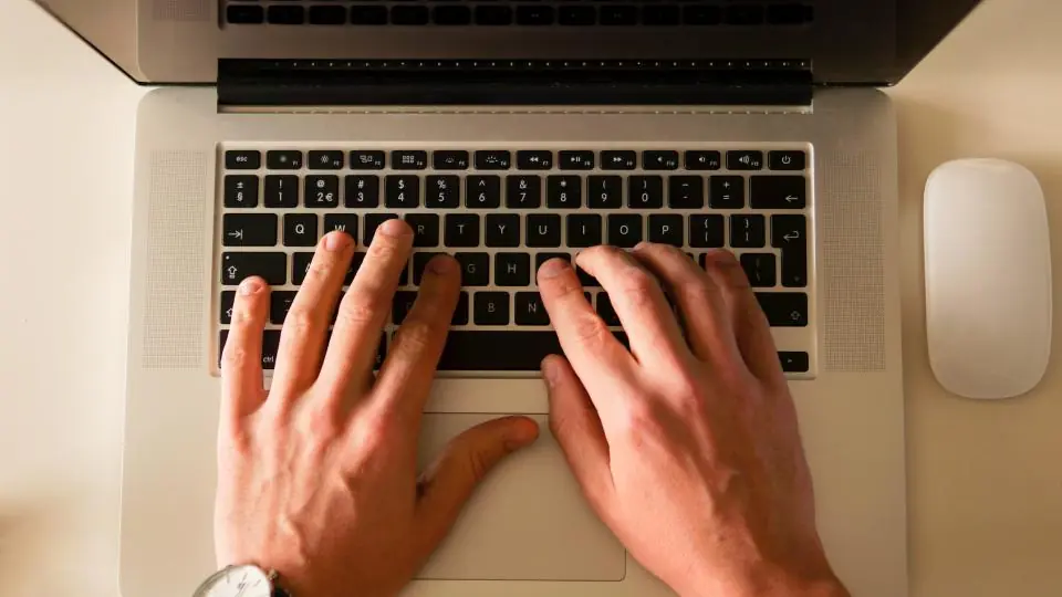 Hands on a laptop keyboard, seen from above