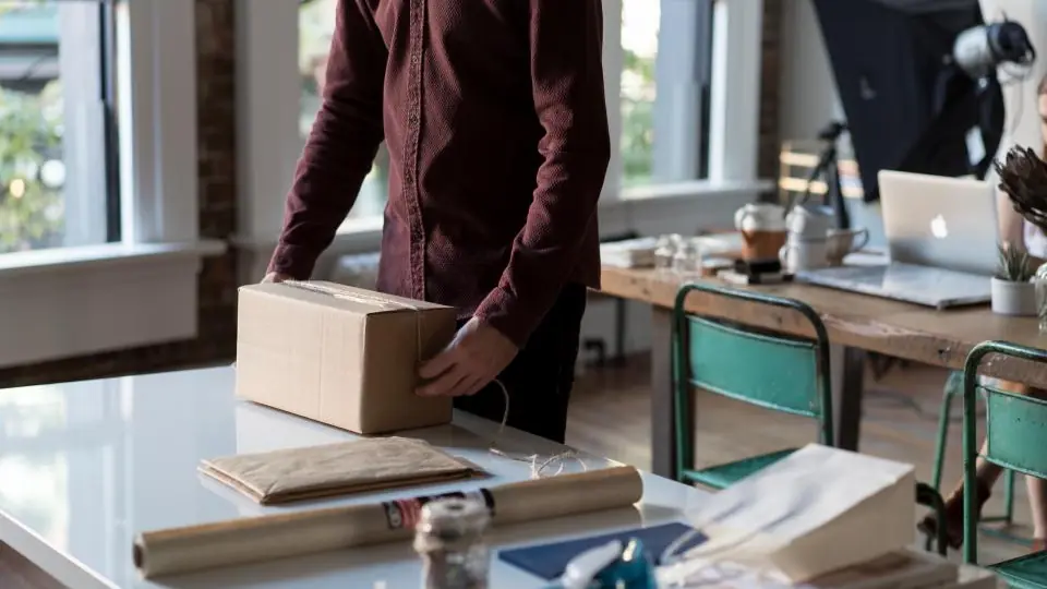 Person packing boxes on a table